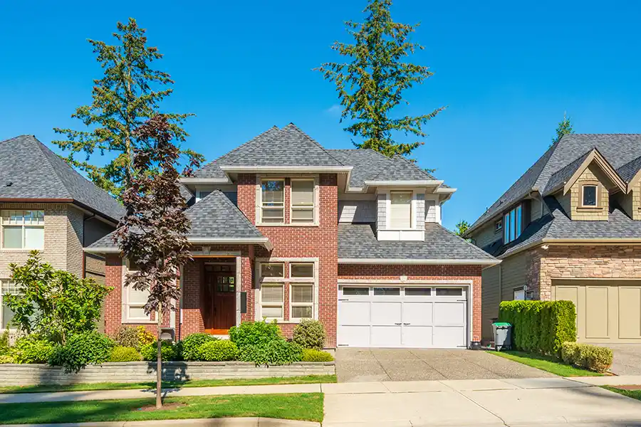 Red brick home with a gray shingle roof